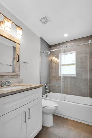 a bathroom with a double vanity sink toilet mirror and bathtub