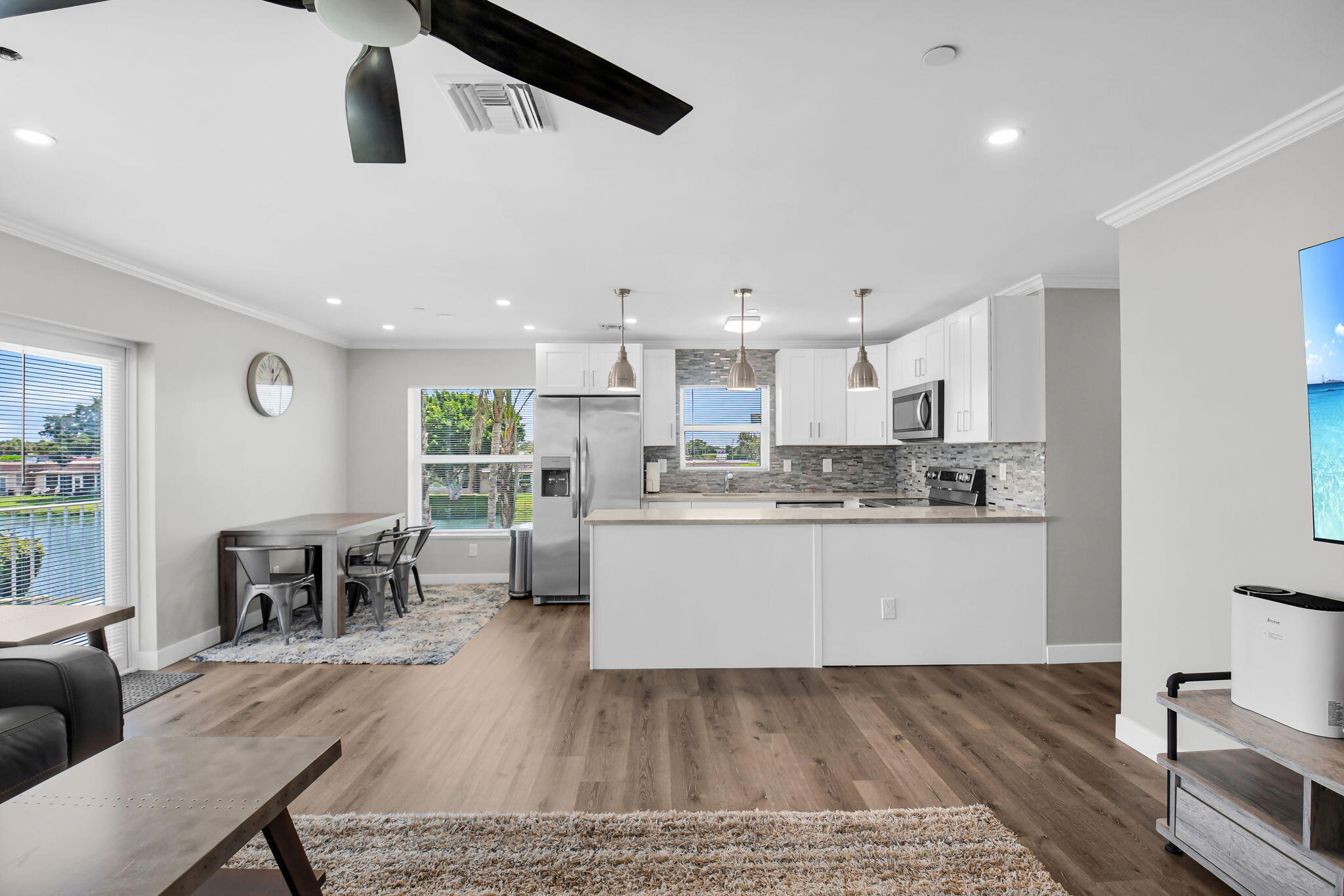 388 Tuscany Lane, Unit 388 Delray Beach, FL 33446 - Photo 8 of 40 a kitchen with stainless steel appliances granite countertop a stove top oven a sink a dining table and chairs with wooden floor