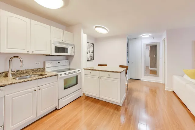 a kitchen with granite countertop cabinets and chairs