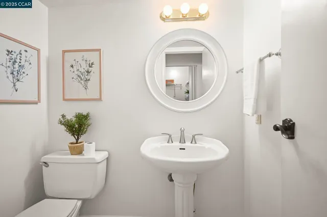 a bathroom with a toilet a sink and mirror