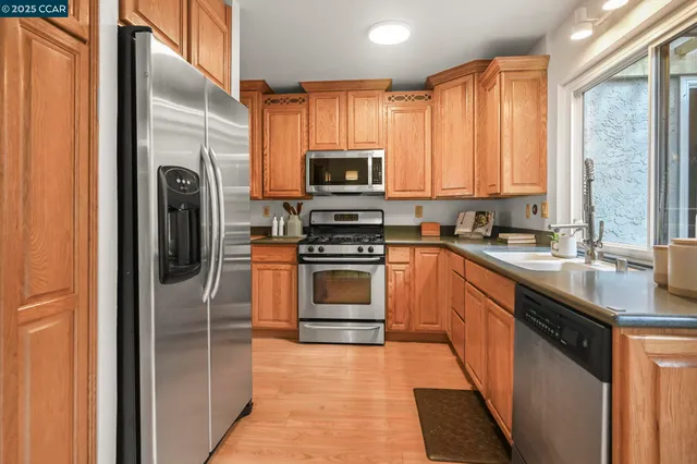 a kitchen with stainless steel appliances granite countertop a stove a refrigerator and a sink