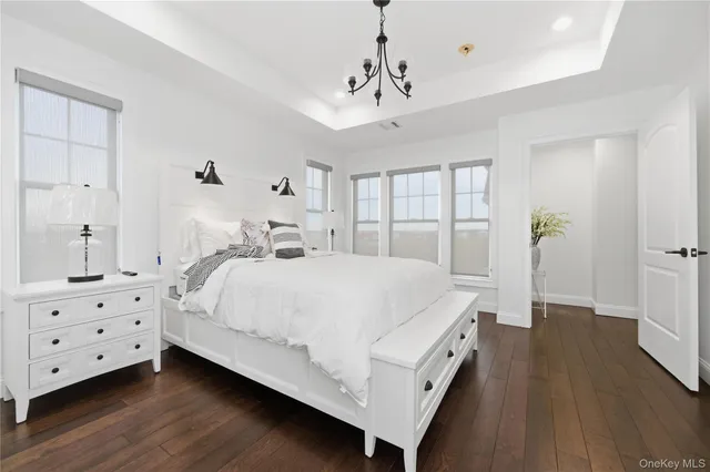 a spacious bedroom with a bed and wooden floor