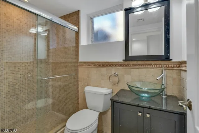 a bathroom with a granite countertop toilet a sink and mirror