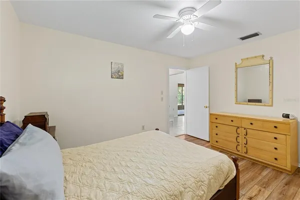 a bedroom with a bed and a chandelier fan