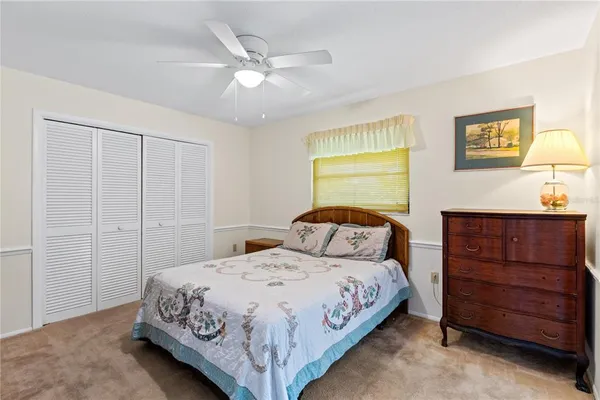 a bedroom with a bed a dresser and painting on the wall