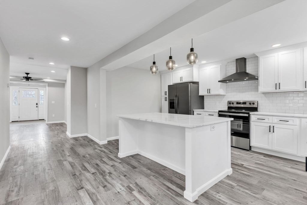 74 Ruggles Street Three Rivers, MA 01080 - Photo 13 of 42 a kitchen with stainless steel appliances kitchen island hardwood floor sink and stove