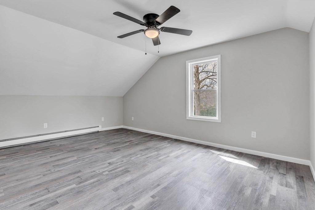 74 Ruggles Street Three Rivers, MA 01080 - Photo 29 of 42 an empty room with wooden floor ceiling fan and windows