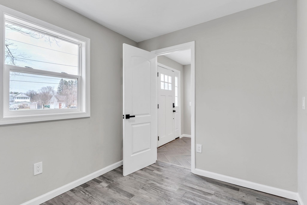 74 Ruggles Street Three Rivers, MA 01080 - Photo 6 of 42 an empty room with wooden floor and windows