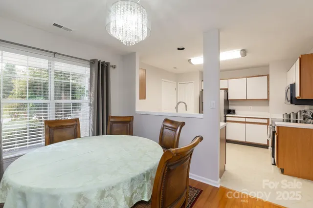 a kitchen with stainless steel appliances a table chairs and chandelier