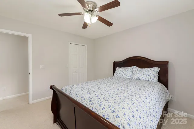 a large bed in a bedroom next to a window