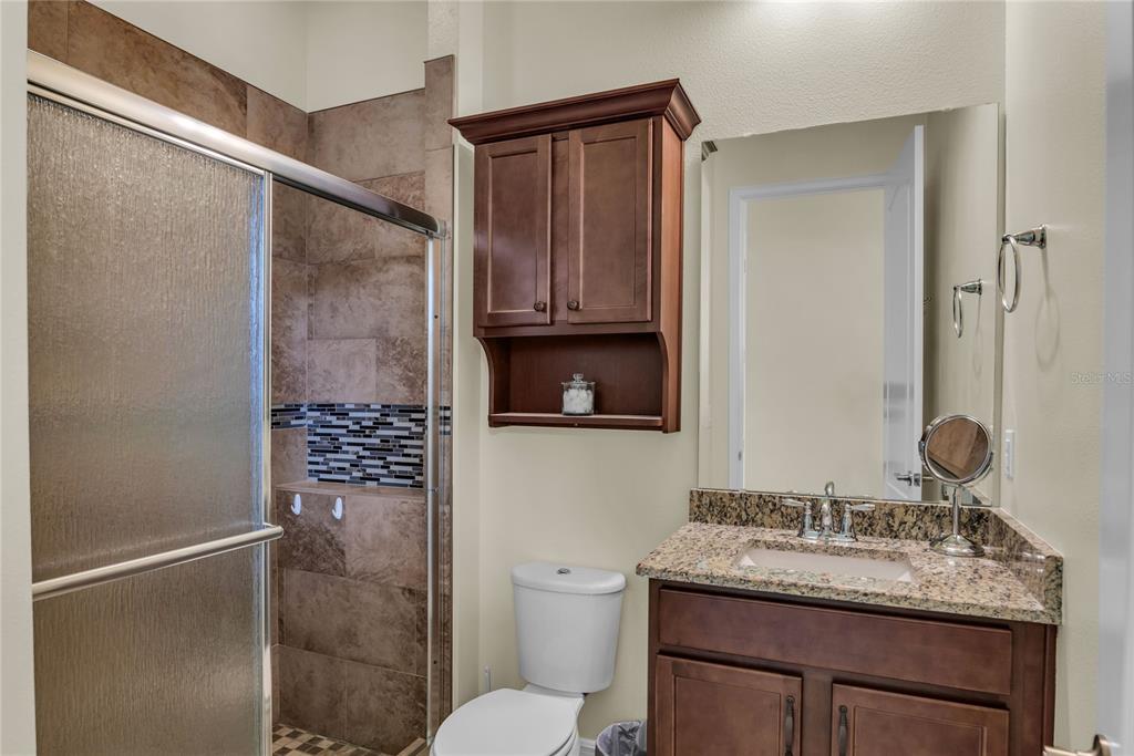 2665 Meadowedge Loop St. Cloud, FL 34772 - Photo 35 of 53 a bathroom with a granite countertop sink toilet and shower