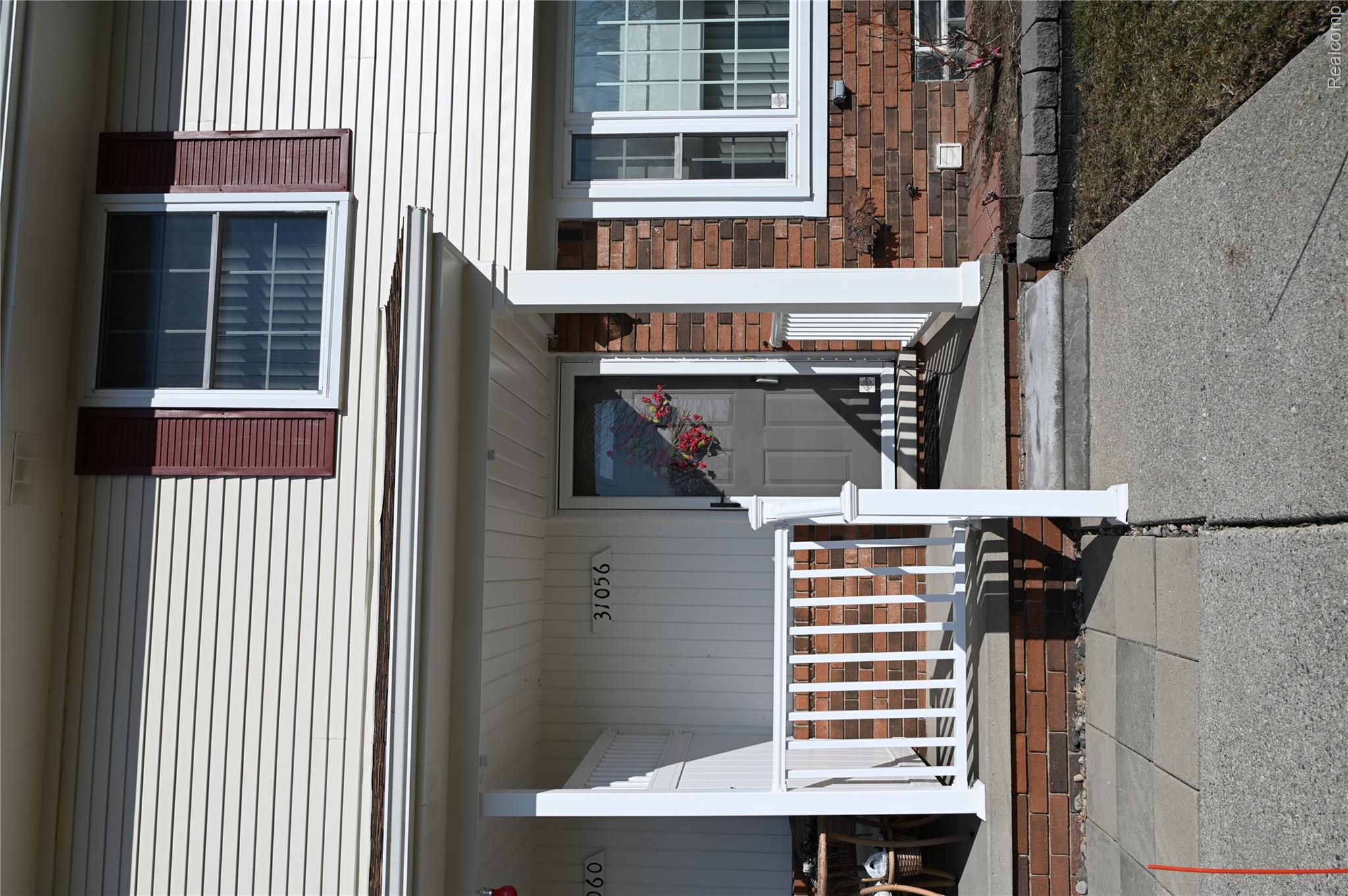 31056 Richert Street, Unit 8 Fraser, MI 48026 - Photo 5 of 19 View of exterior entry with a covered porch and brick siding