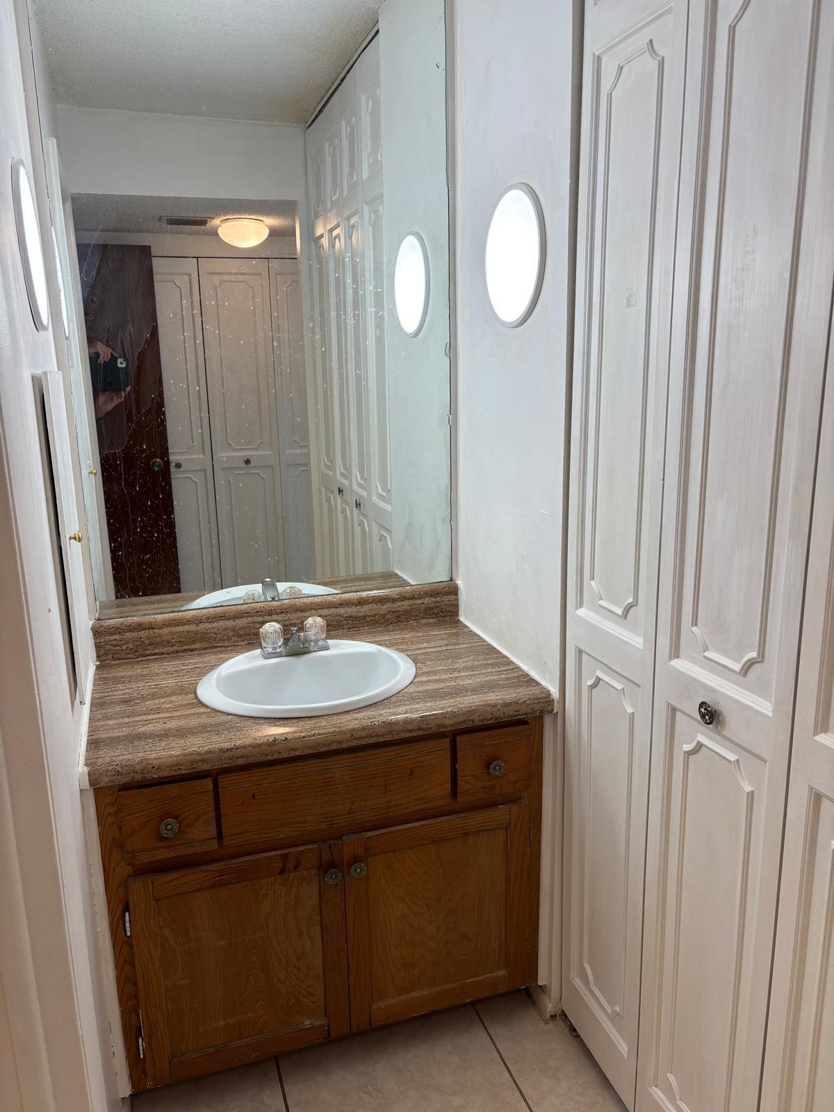 3650 Inverrary Drive, Unit 1K Lauderhill, FL 33319 - Photo 9 of 13 a bathroom with a sink and a mirror
