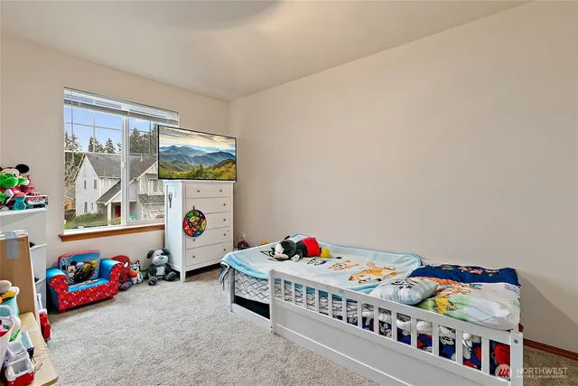 a living room with furniture and baby crib