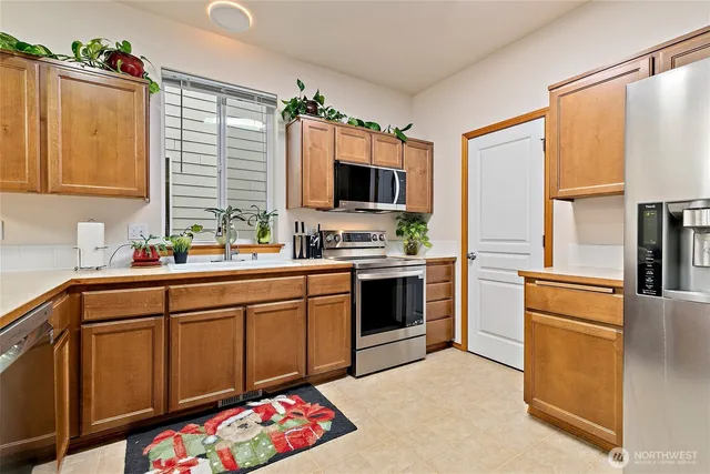 a kitchen with stainless steel appliances kitchen island granite countertop a sink stove and refrigerator