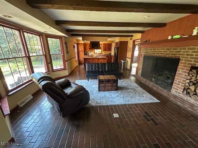 1975 Warner Road Southeast Hubbard, OH 44425 - Photo 8 of 23 Living area with brick flooring, beamed ceiling, and a brick fireplace