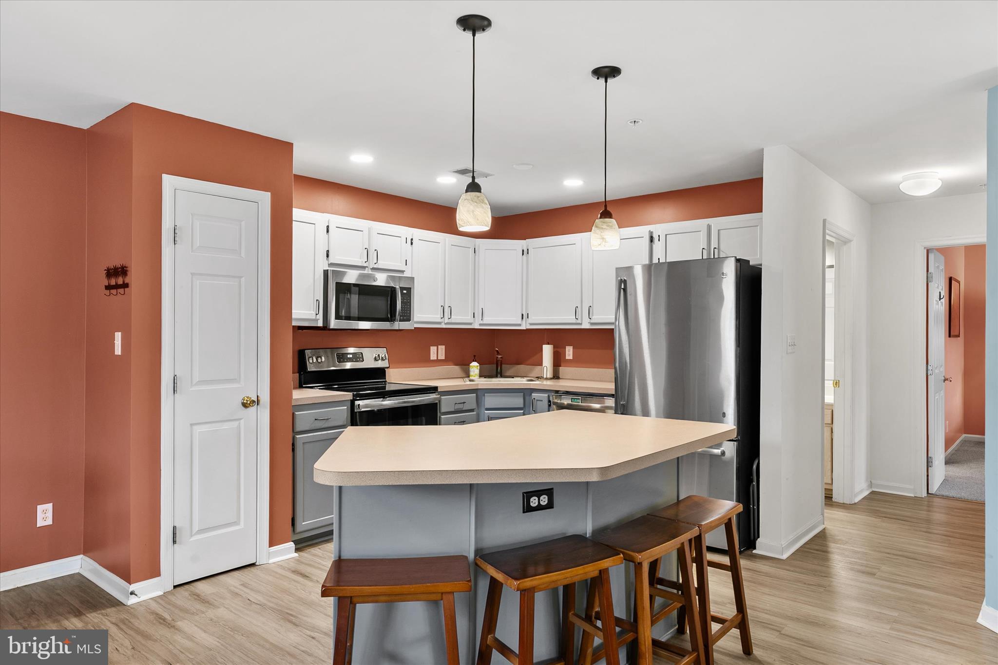 11423 Manklin Creek Road, Unit 1 Ocean Pines, MD 21811 - Photo 3 of 40 a kitchen with a table chairs refrigerator and microwave