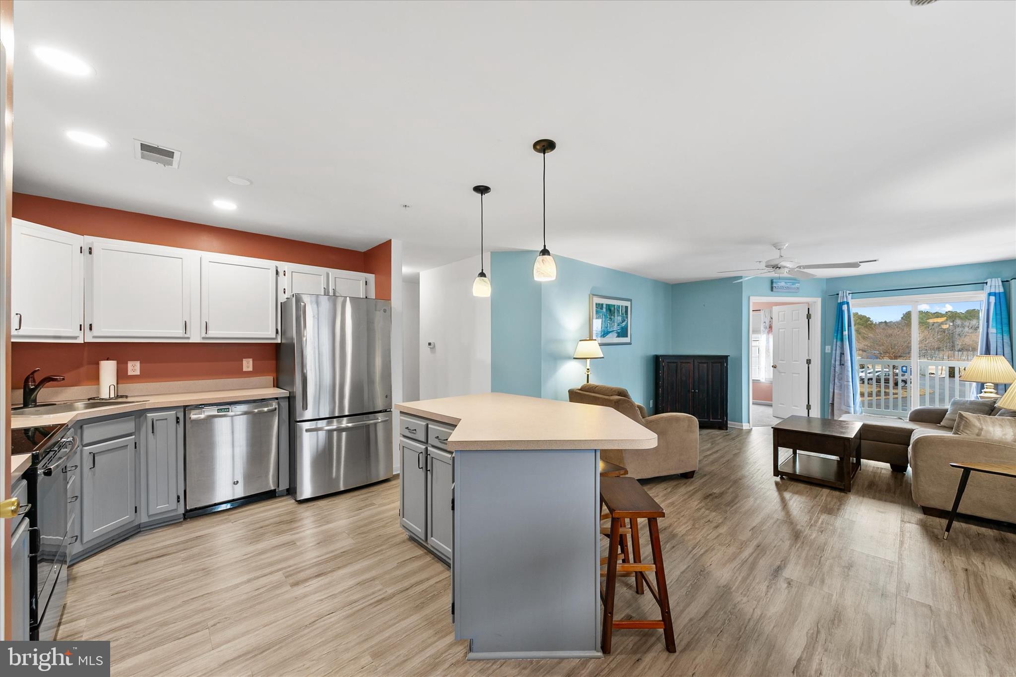 11423 Manklin Creek Road, Unit 1 Ocean Pines, MD 21811 - Photo 6 of 40 a large kitchen with a table chairs refrigerator and microwave