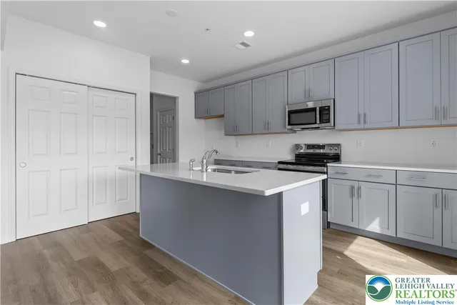 a kitchen with kitchen island white cabinets and refrigerator