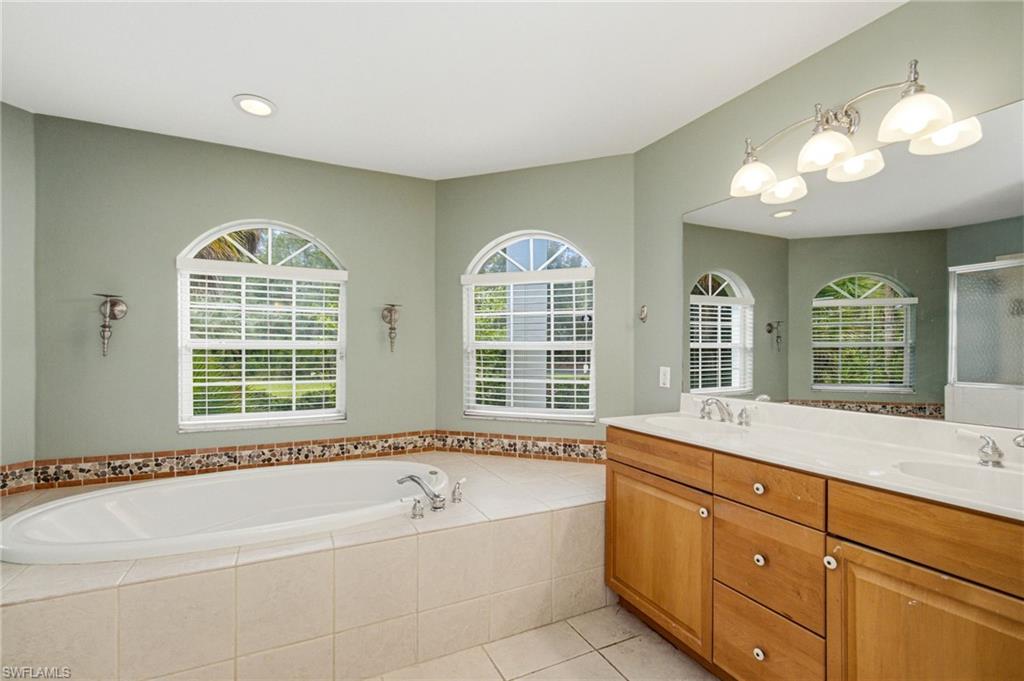2053 17th Street Southwest Naples, FL 34117 - Photo 16 of 47 a spacious bathroom with a tub a sink and large windows