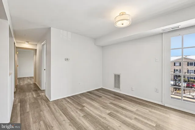 a view of a room with wooden floor and entryway