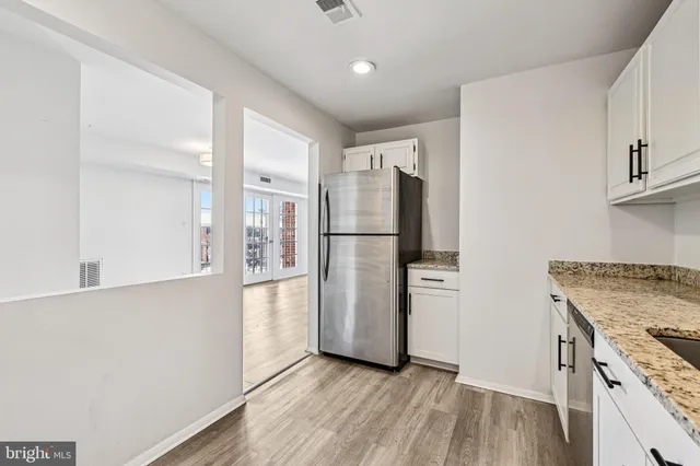 a kitchen with stainless steel appliances granite countertop a refrigerator and a stove top oven