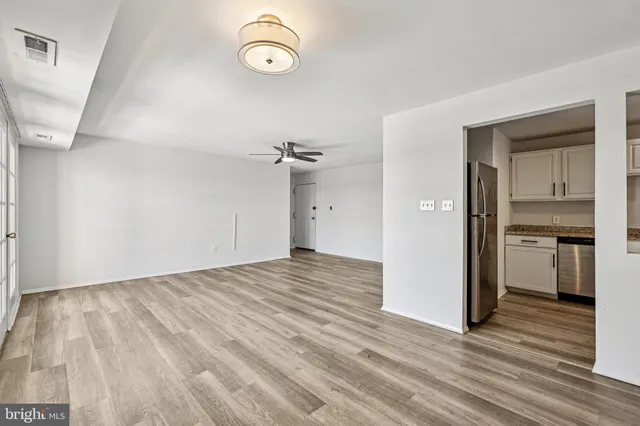 a view of empty room with wooden floor