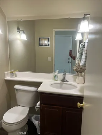 a bathroom with a toilet a sink and mirror