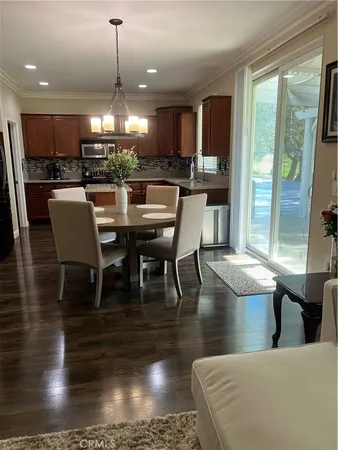 a kitchen with stainless steel appliances granite countertop a stove a refrigerator a kitchen island a dining table and chairs