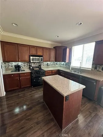 a kitchen with stainless steel appliances granite countertop a stove a sink dishwasher a microwave oven and a oven