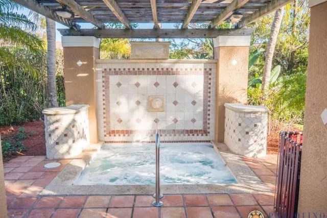 a view of swimming pool with a garden and patio