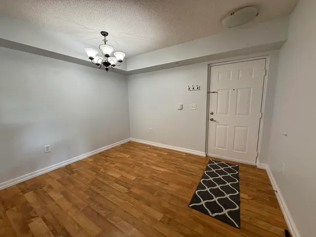 a view of an empty room with a chandelier fan