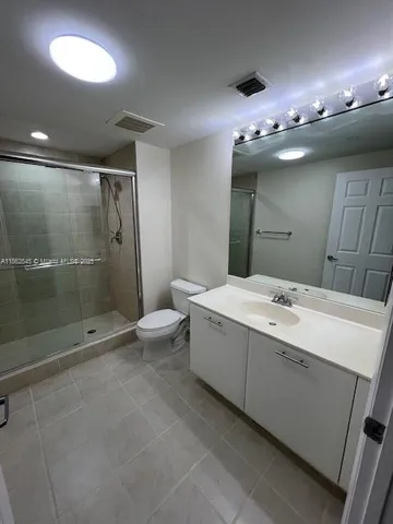 a bathroom with a double vanity sink mirror and toilet
