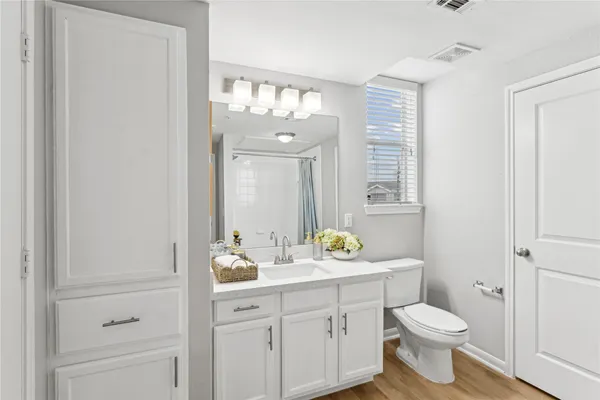 a bathroom with a sink a toilet and a mirror