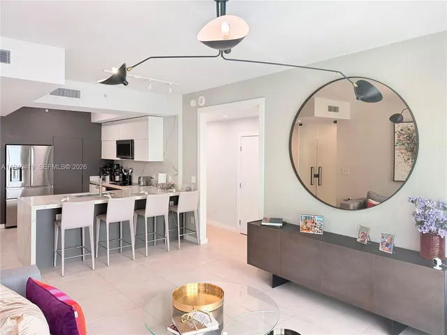 a living room with furniture a mirror and a chandelier