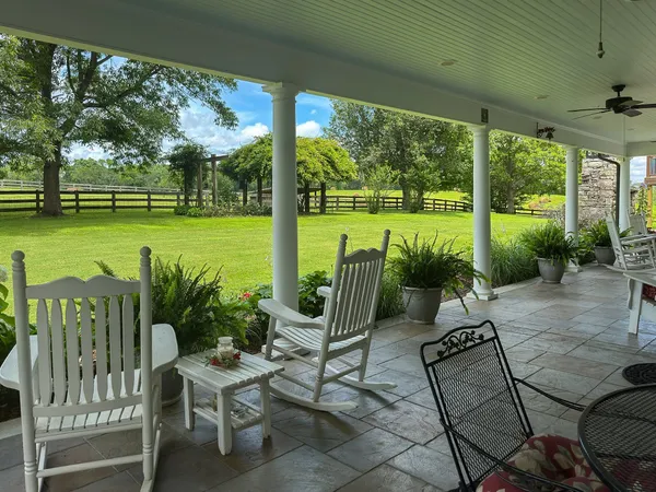a view of a patio with chairs and floor to ceiling window