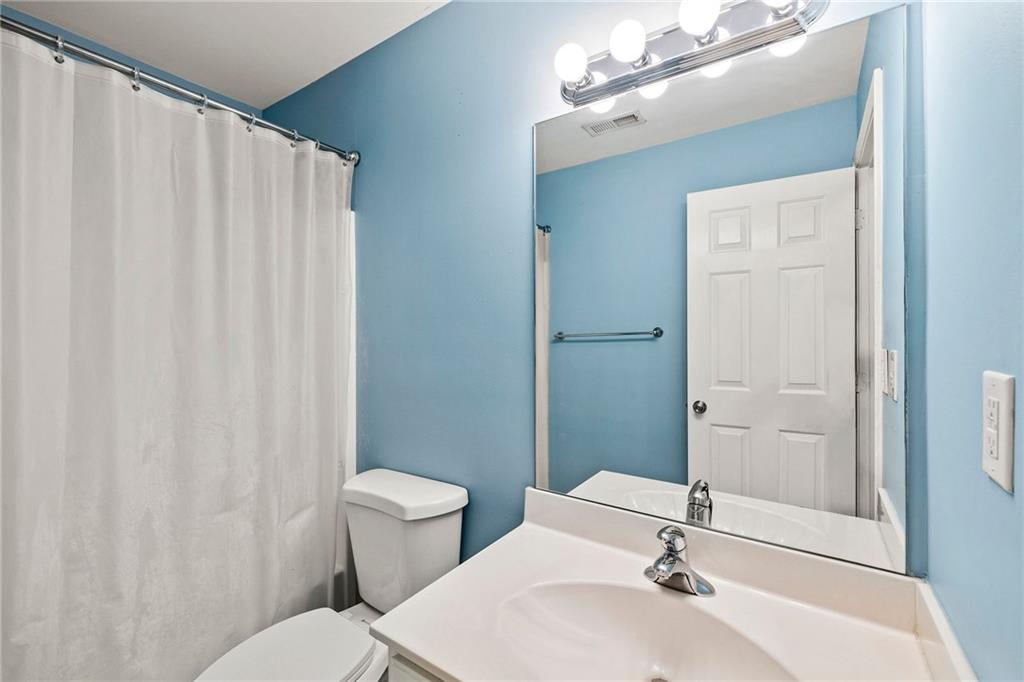 5323 Sherwin Drive Norcross, GA 30093 - Photo 13 of 20 a bathroom with a sink a toilet a mirror and shower curtain