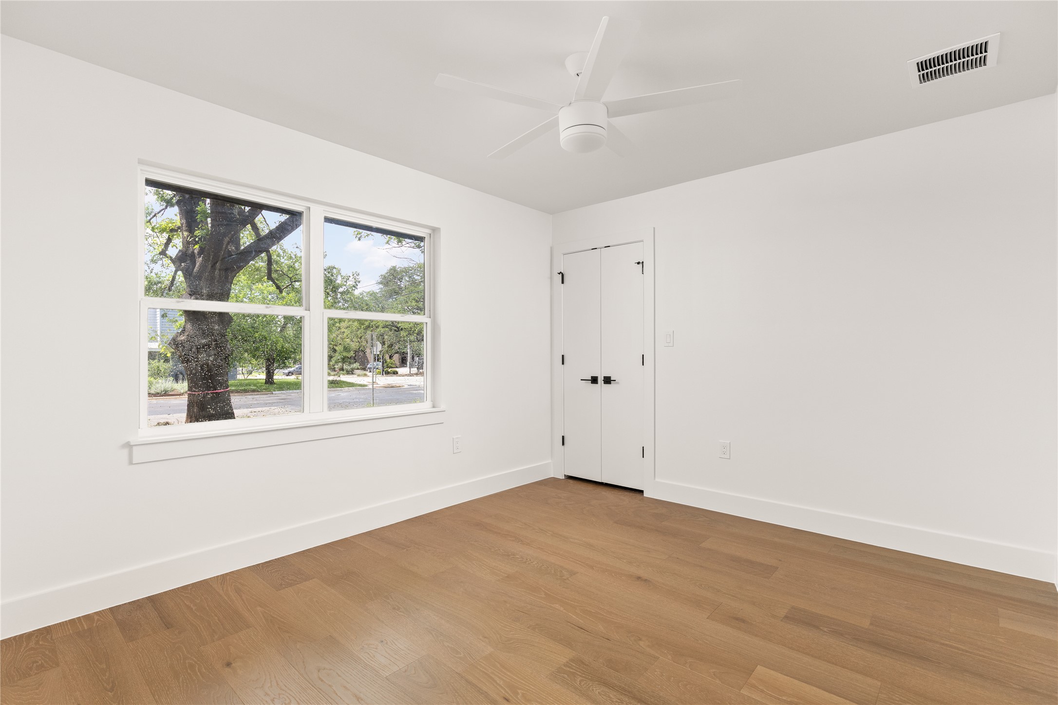 4501 Pack Saddle Pass Austin, TX 78745 - Photo 29 of 37 Light-filled room featuring wood-finish flooring, a contemporary ceiling fan, and a double-pane window