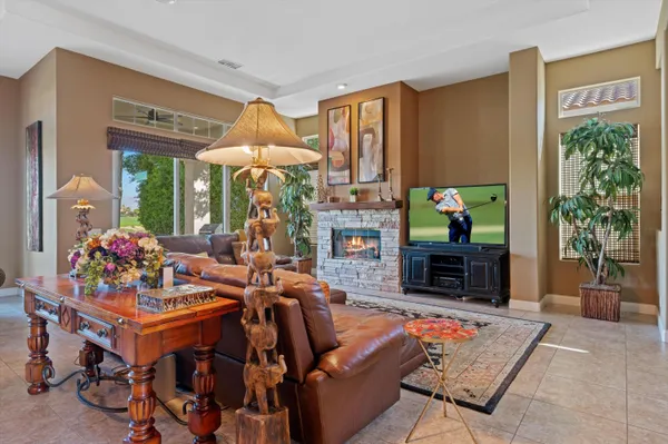 a living room with furniture a fireplace and a potted plant