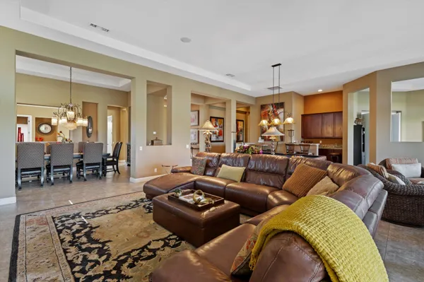 a living room with furniture kitchen view and a large window