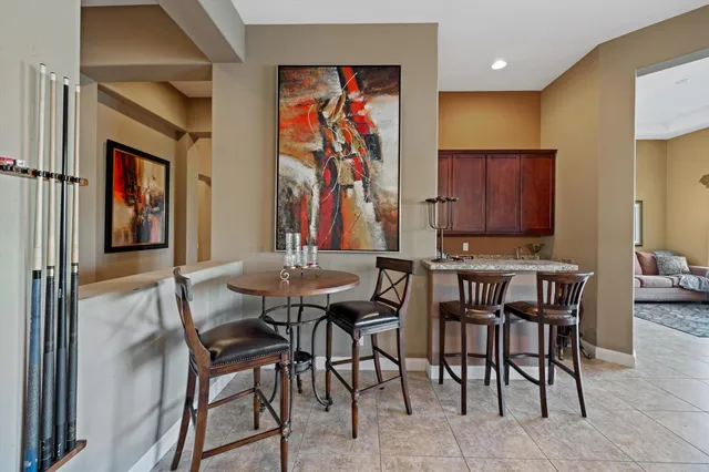 a view of a dining room with furniture a chandelier and window