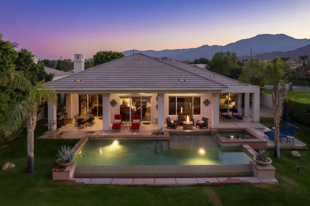 a view of a house with swimming pool and sitting area