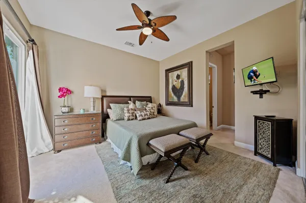 a bedroom with a large bed a flat tv screen and dresser