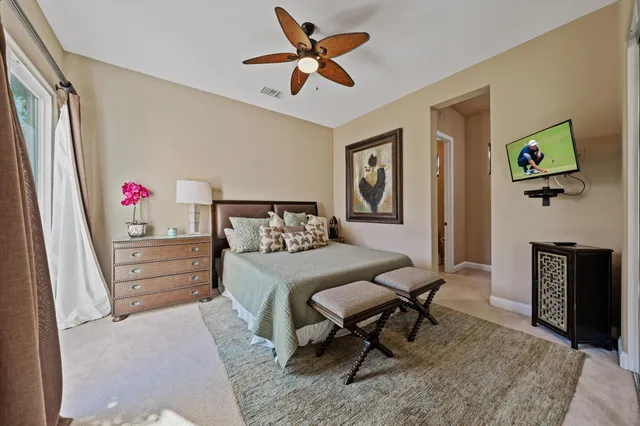 a bedroom with a large bed a flat tv screen and dresser