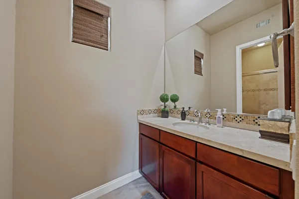 a bathroom with a granite countertop sink mirror and toilet