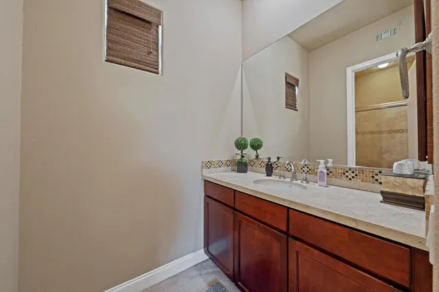 a bathroom with a granite countertop sink mirror and toilet