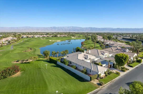 a view of a white house with potted plants
