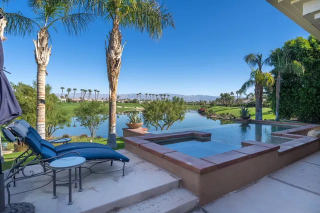 a view of a chairs and table in patio with a lake view