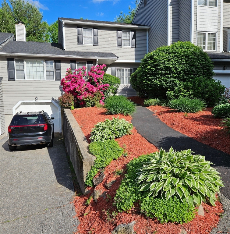 202 Torrey Ln Extension, Unit 202 Holden, MA 01520 - Photo 3 of 32 a front view of a house with a yard and a lot of flower plants