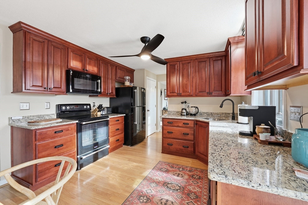202 Torrey Ln Extension, Unit 202 Holden, MA 01520 - Photo 9 of 32 a kitchen with stainless steel appliances granite countertop a stove sink microwave and cabinets